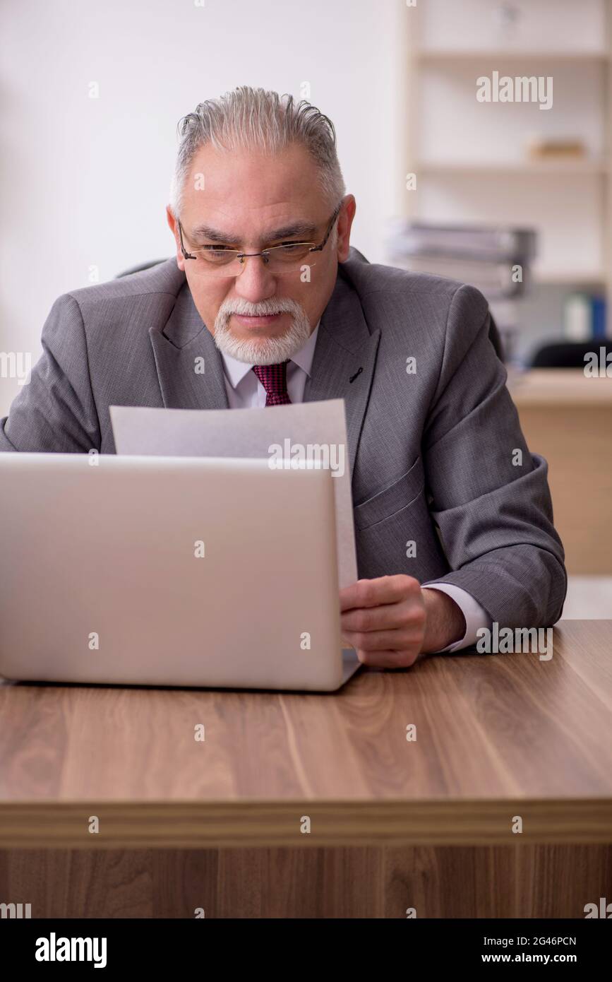Old businessman employee working at workplace Stock Photo - Alamy