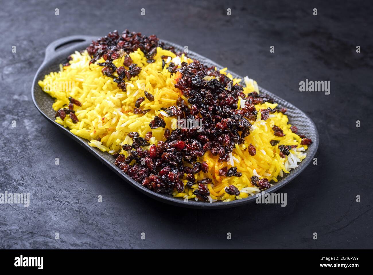 Modern style traditional Persian steamed saffron rice with berberis served as closeup on a cast