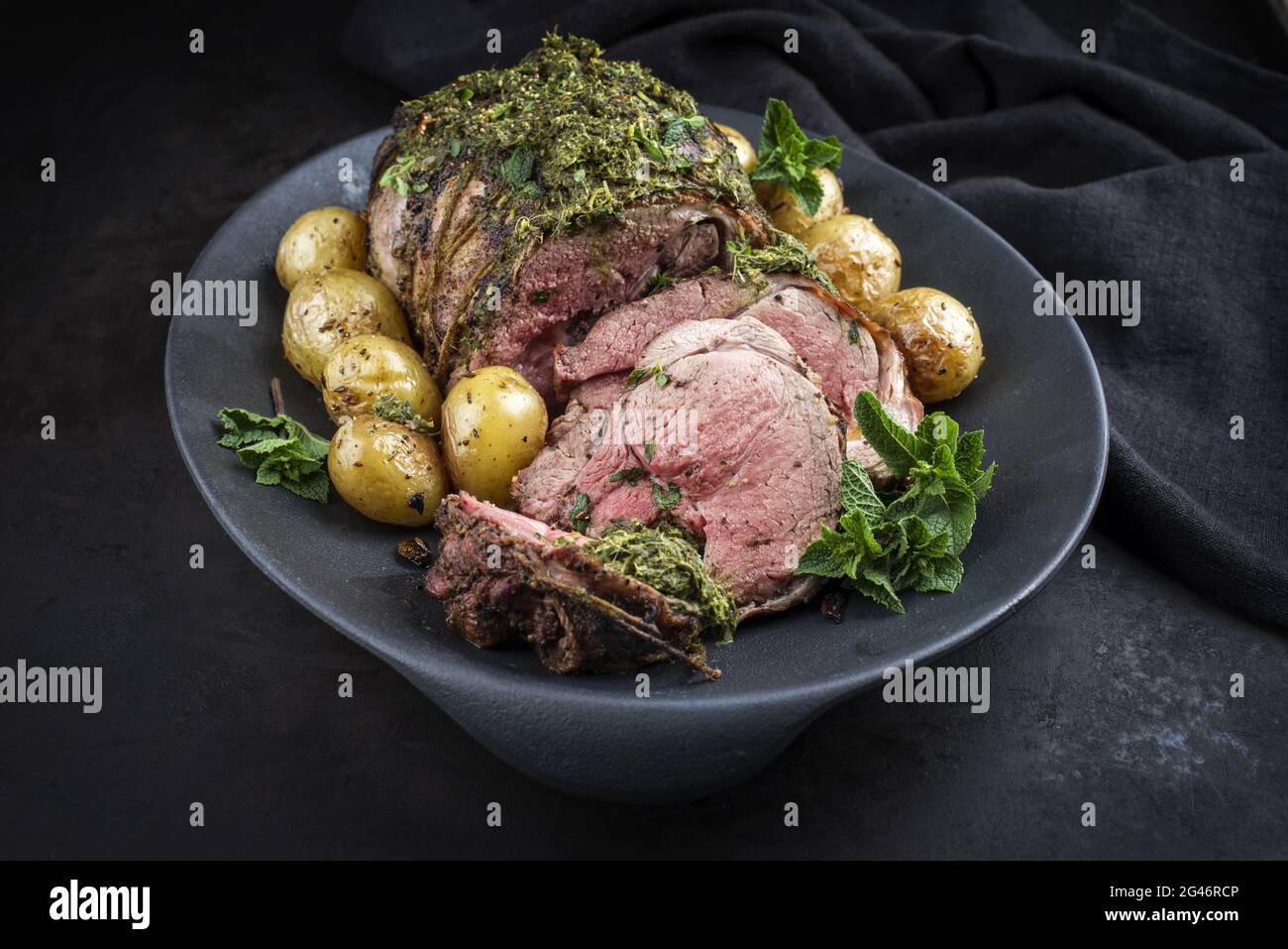 Traditional English barbecue lamb roast sliced with mint sauce and