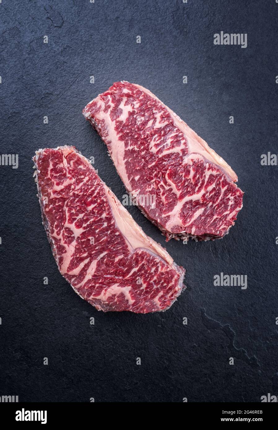 Raw dry aged wagyu roast beef steak offered as top view on a black board  with copy space Stock Photo - Alamy