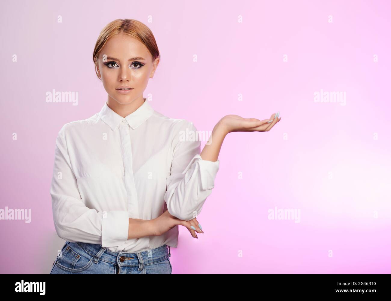 Young woman show open palm isolated on pink background Stock Photo