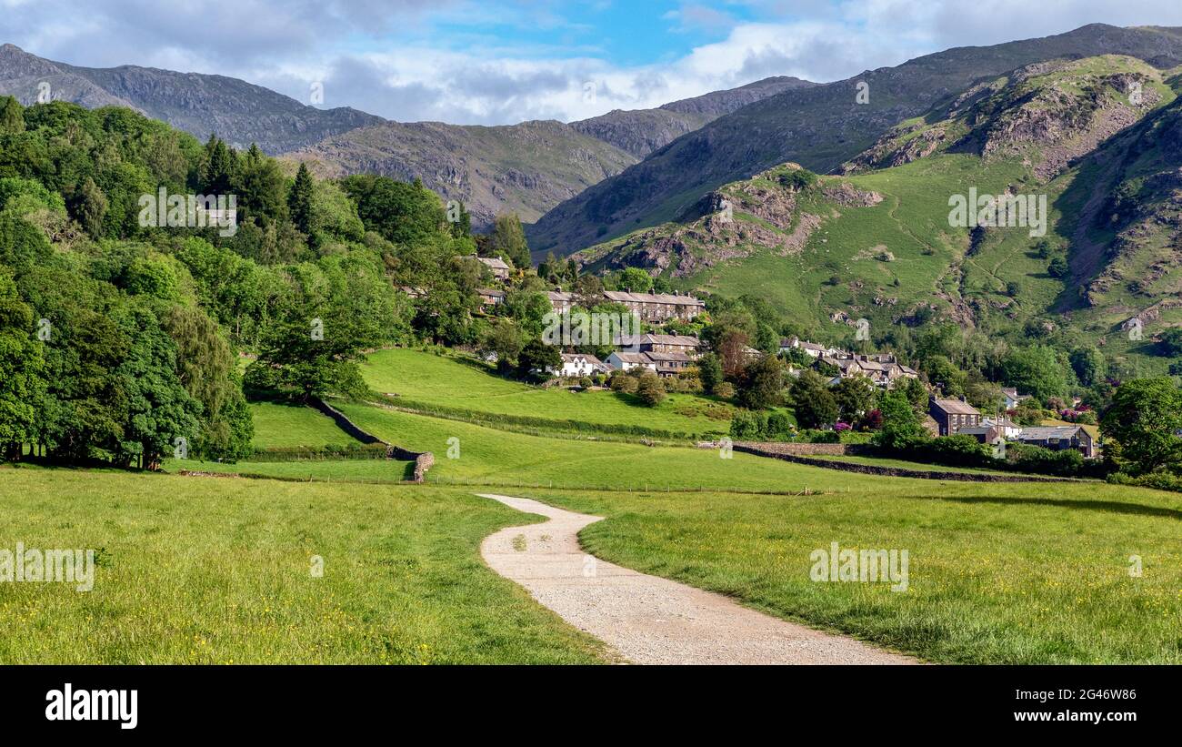 Coniston village and surrounding mountains viewed from a public footpath from Coniston during early summer in the Lake District Stock Photo