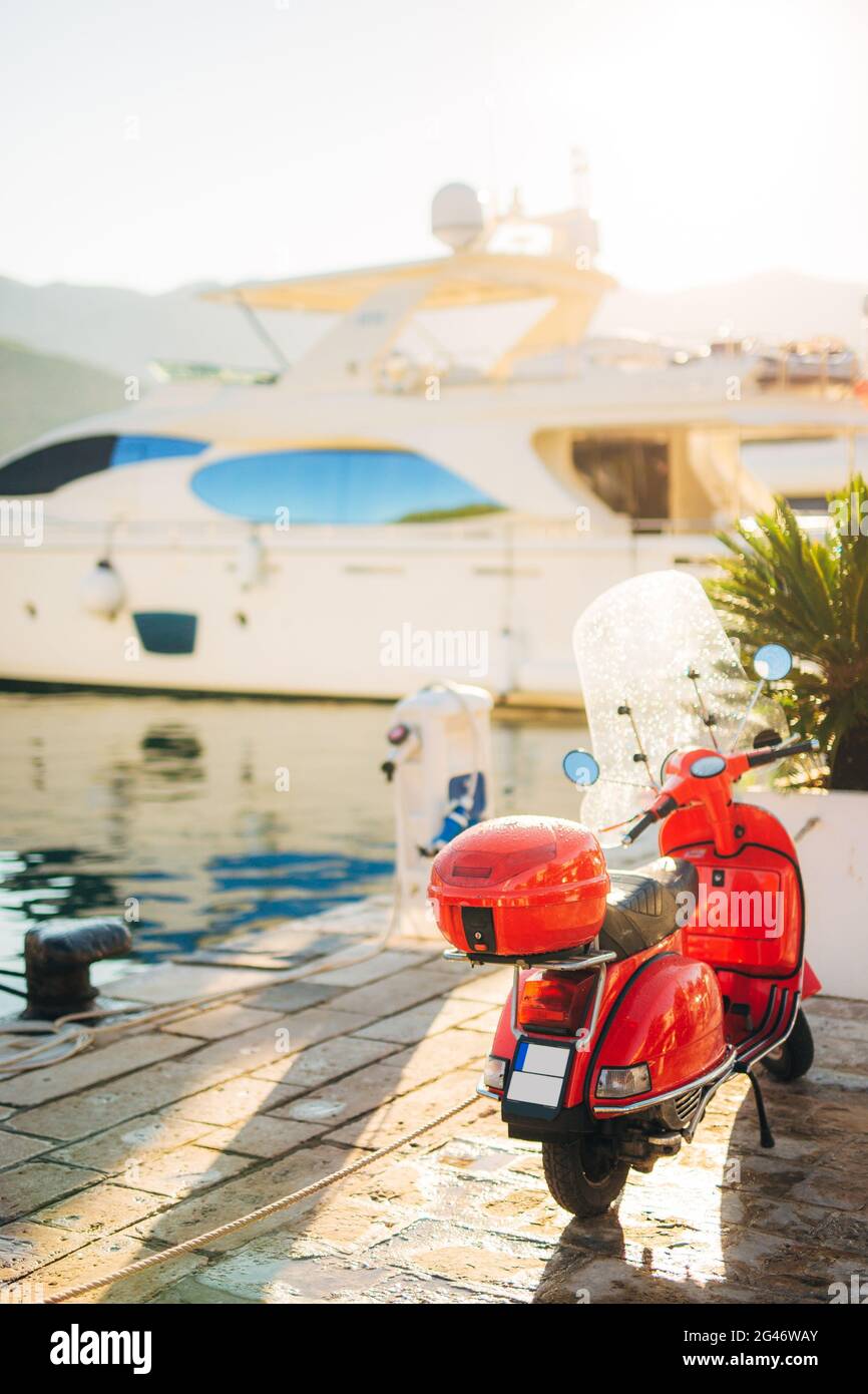A red retro moped parked at the marina. Stock Photo
