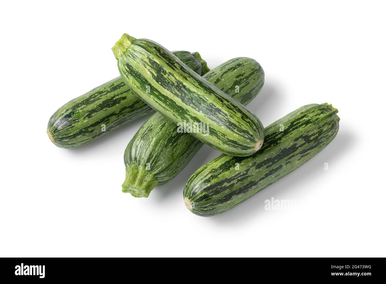 Heap of fresh raw green spotted courgette close up isolated on white background Stock Photo