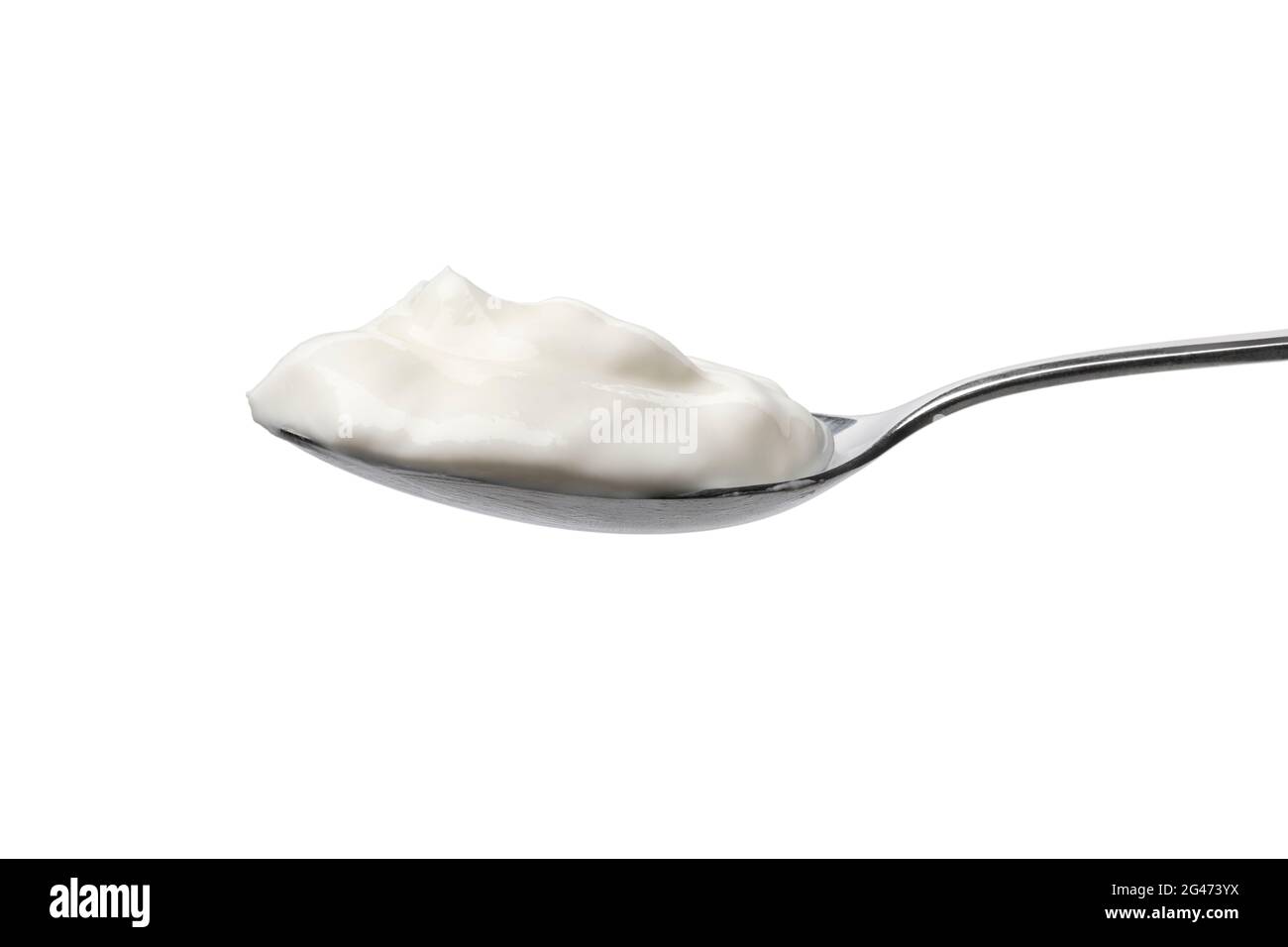 Metal spoon with fresh white organic Greek yoghurt on white background