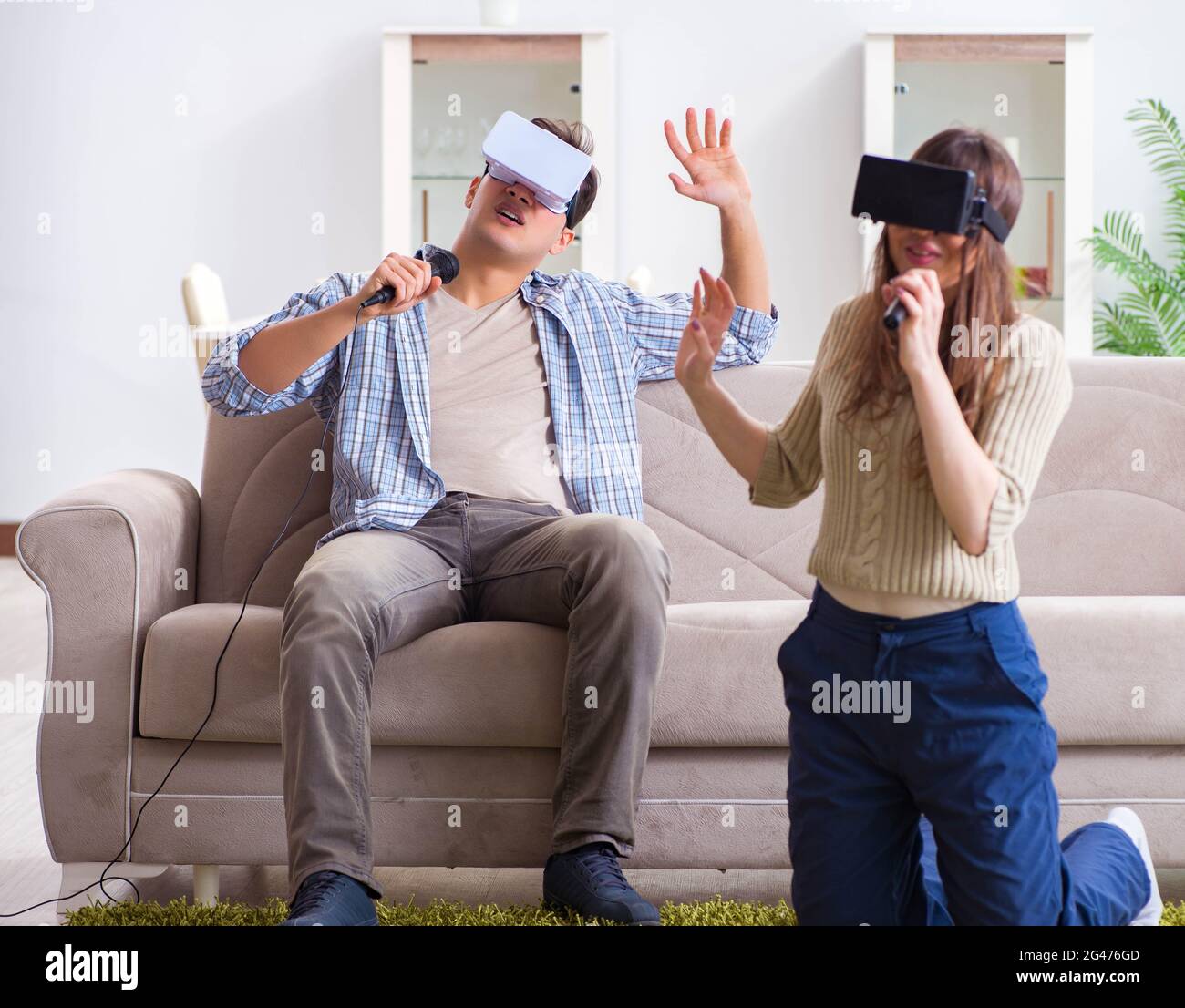 The pair singing karaoke with virtual reality glasses Stock Photo Alamy