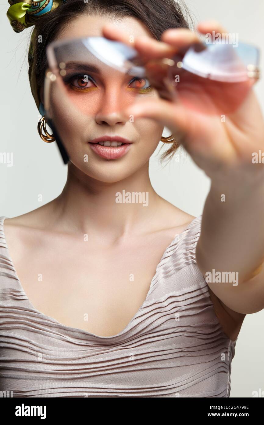 Female in headscarf is looking at the camera through glasses. Stock Photo