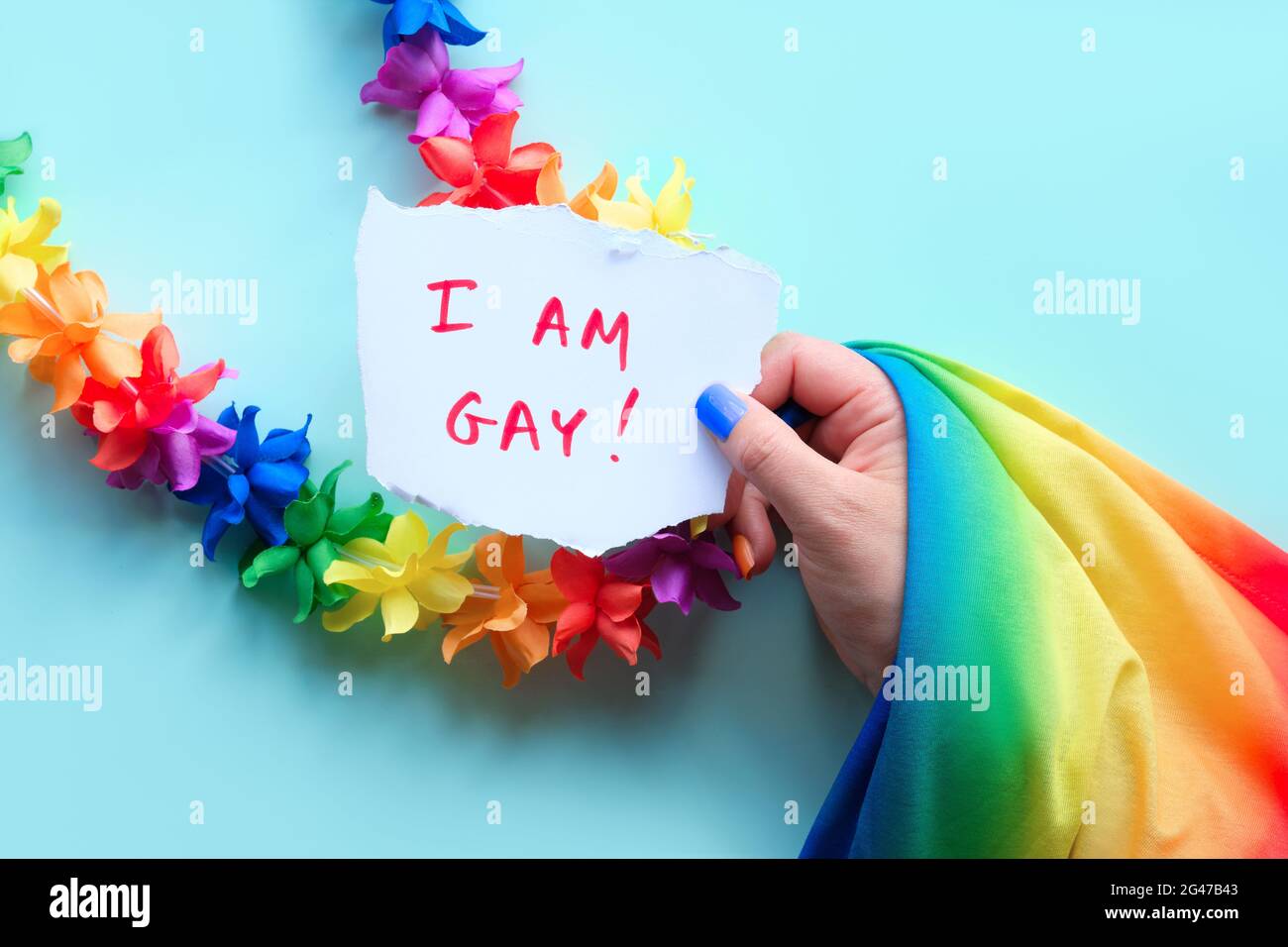 LGBTQ community pride. Text I am Gay on paper in hand with rainbow flag,  flower garland and fake nails in colors of rainbow. Concept shot. Flat lay  Stock Photo - Alamy