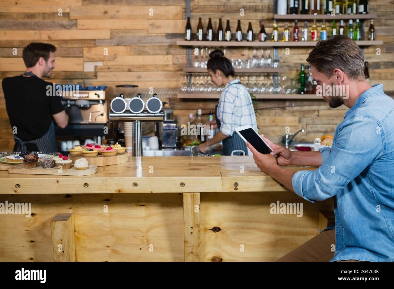 Man using digital tablet at counter Stock Photo