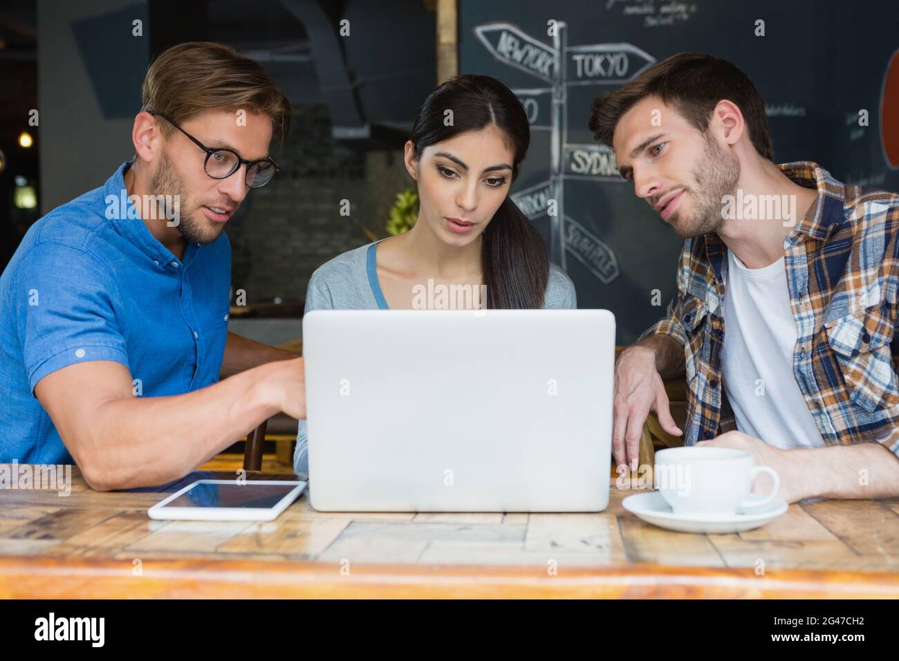 Friends using laptop while having coffee Stock Photo
