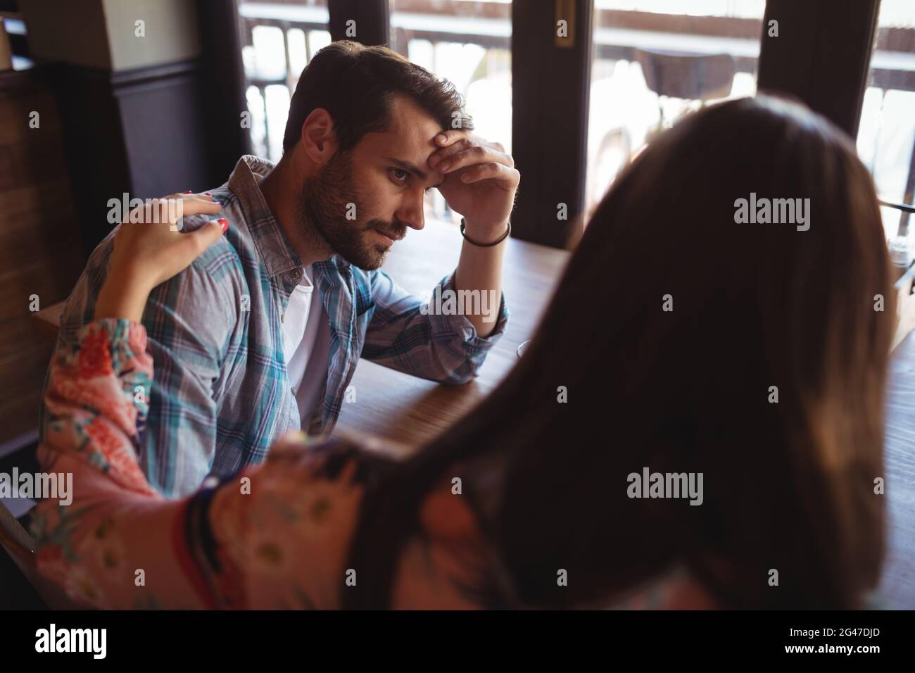 Woman consoling man at counter Stock Photo - Alamy