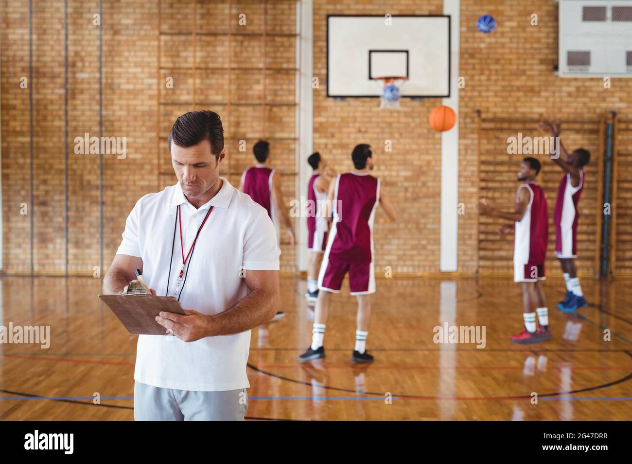 Basketball coach writing on clipboard Stock Photo Alamy