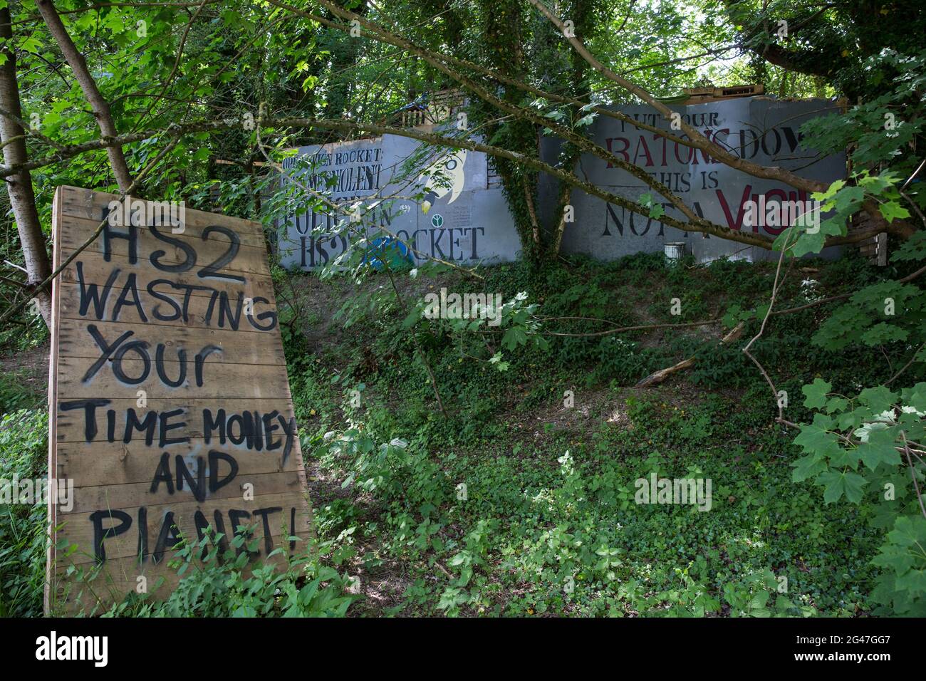 Wendover, UK. 16th June, 2021. Painted signs are pictured outside Stop HS2's Wendover Active Resistance Camp alongside the A413. Large areas of land around Wendover in the Chilterns AONB have already been cleared of trees and vegetation for the HS2 rail infrastructure project in spite of concerted opposition from local residents and environmental activists. Credit: Mark Kerrison/Alamy Live News Stock Photo