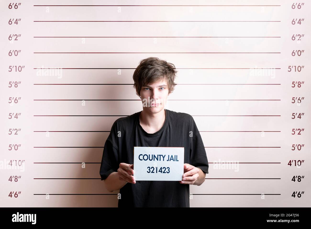 arrested prisoner young man holding a placecard in front of the height
