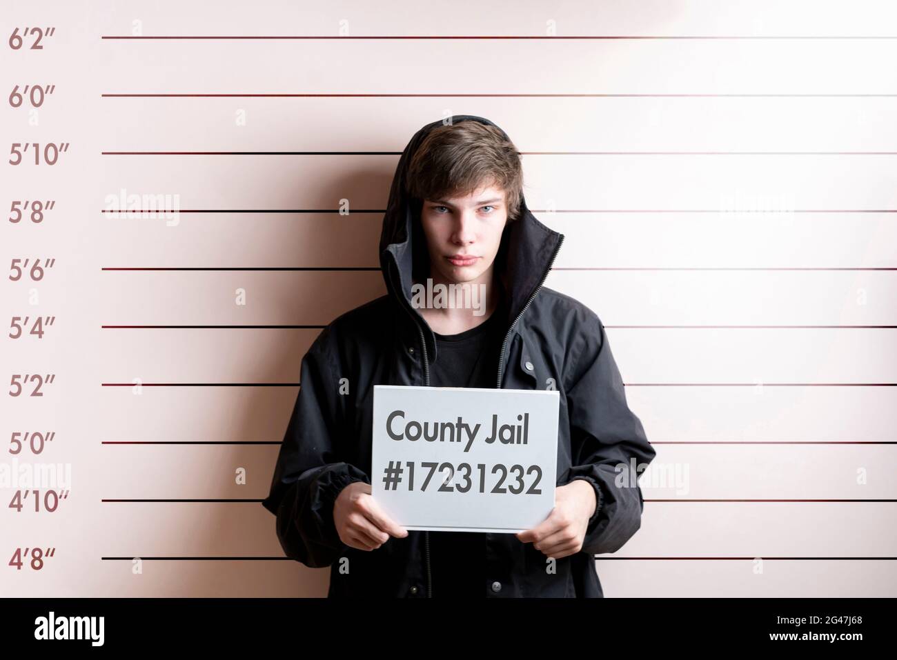 arrested prisoner young man holding a placecard in front of the height