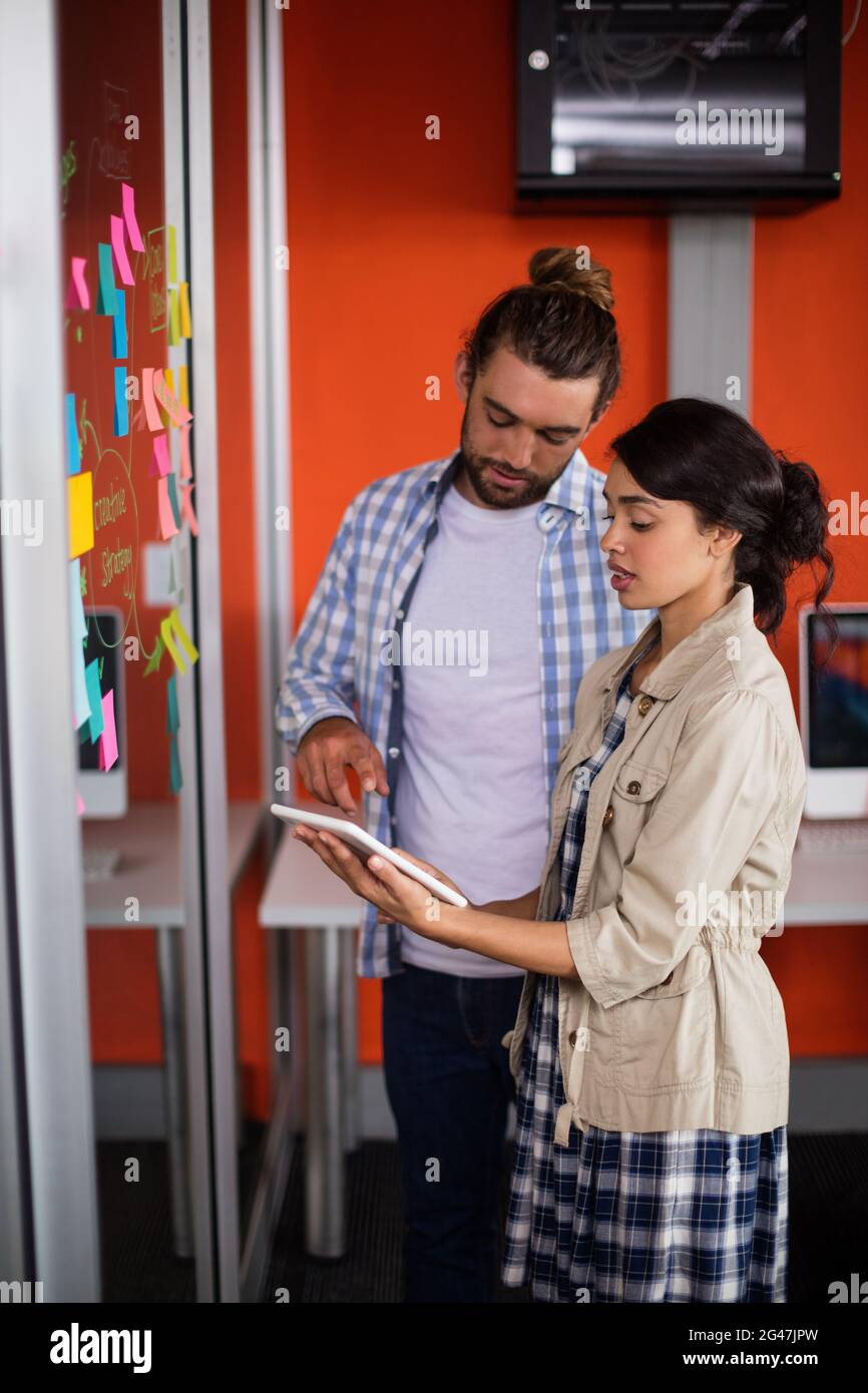 Male and female executives discussing over digital tablet Stock Photo