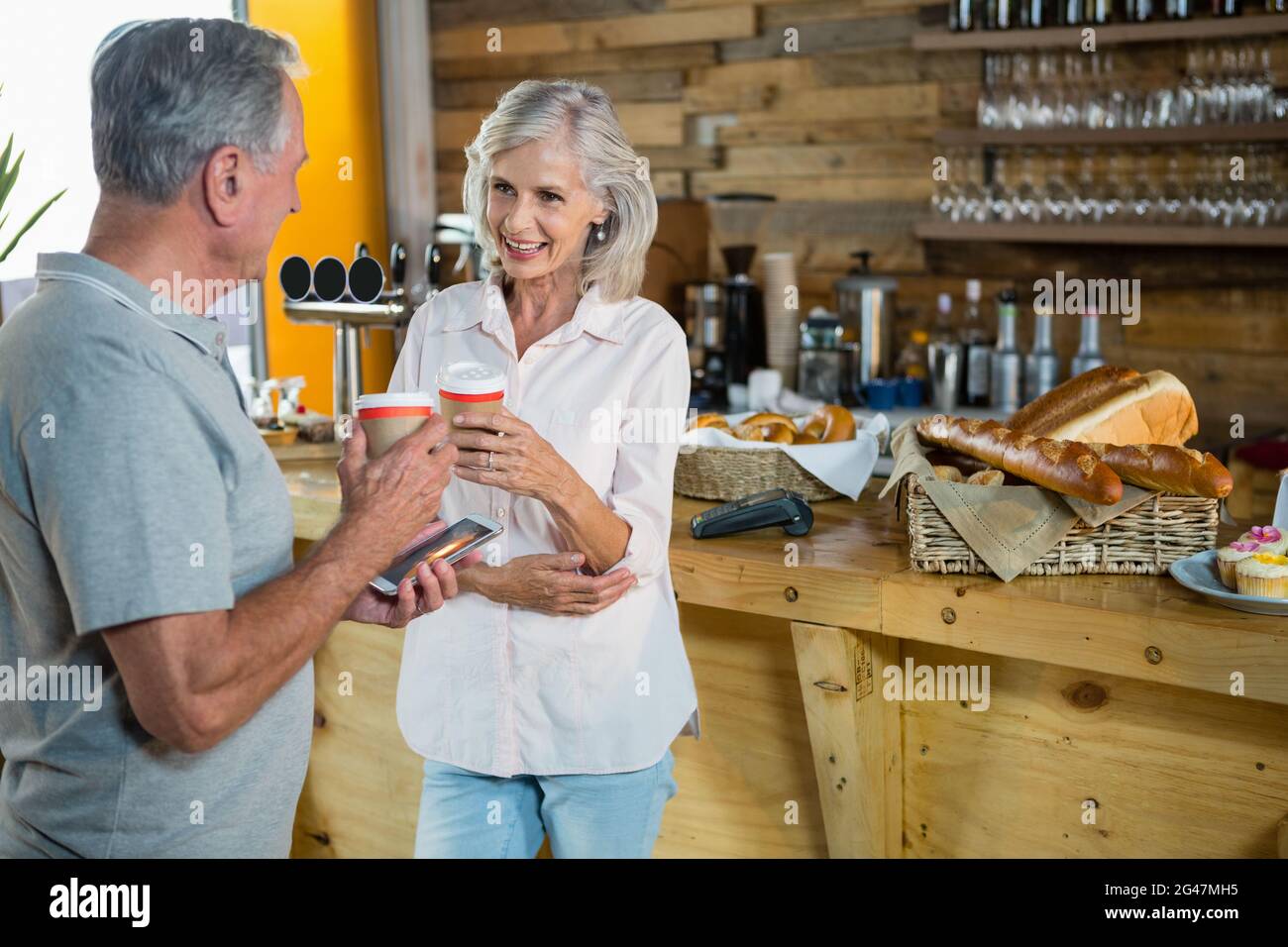 Senior couple interacting with each other while having coffee Stock Photo