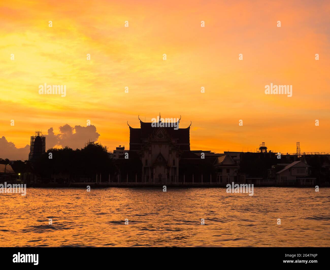 Colorful cloudy twilight sky with silhouette temple and city foreground in Bangkok, Thailand Stock Photo