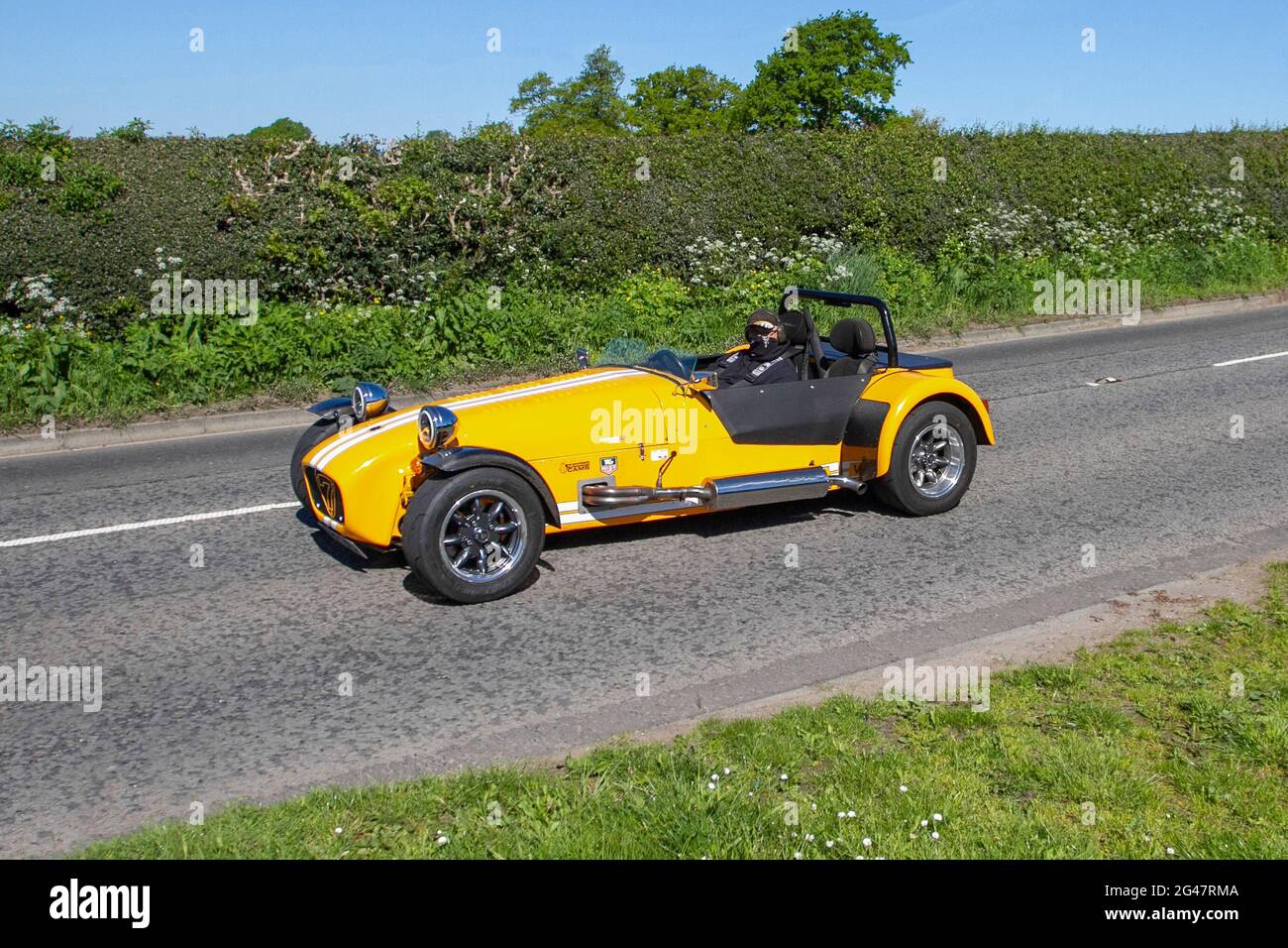 2012 Lowcost yellow Caterham 7 1988cc petrol kit car,  en-route to Capesthorne Hall classic May car show, Cheshire, UK Stock Photo