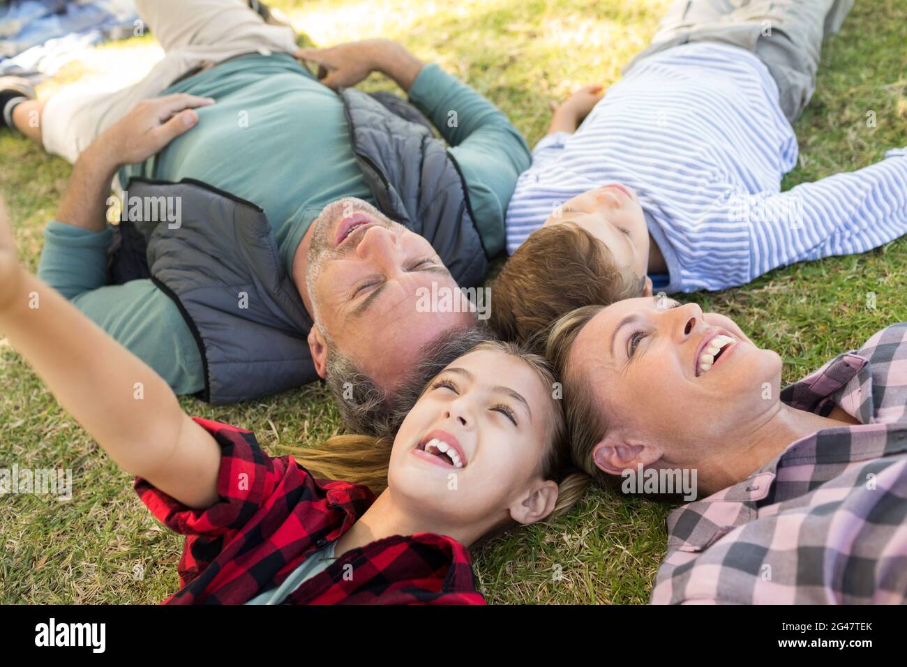 Happy family lying on the grass Stock Photo - Alamy