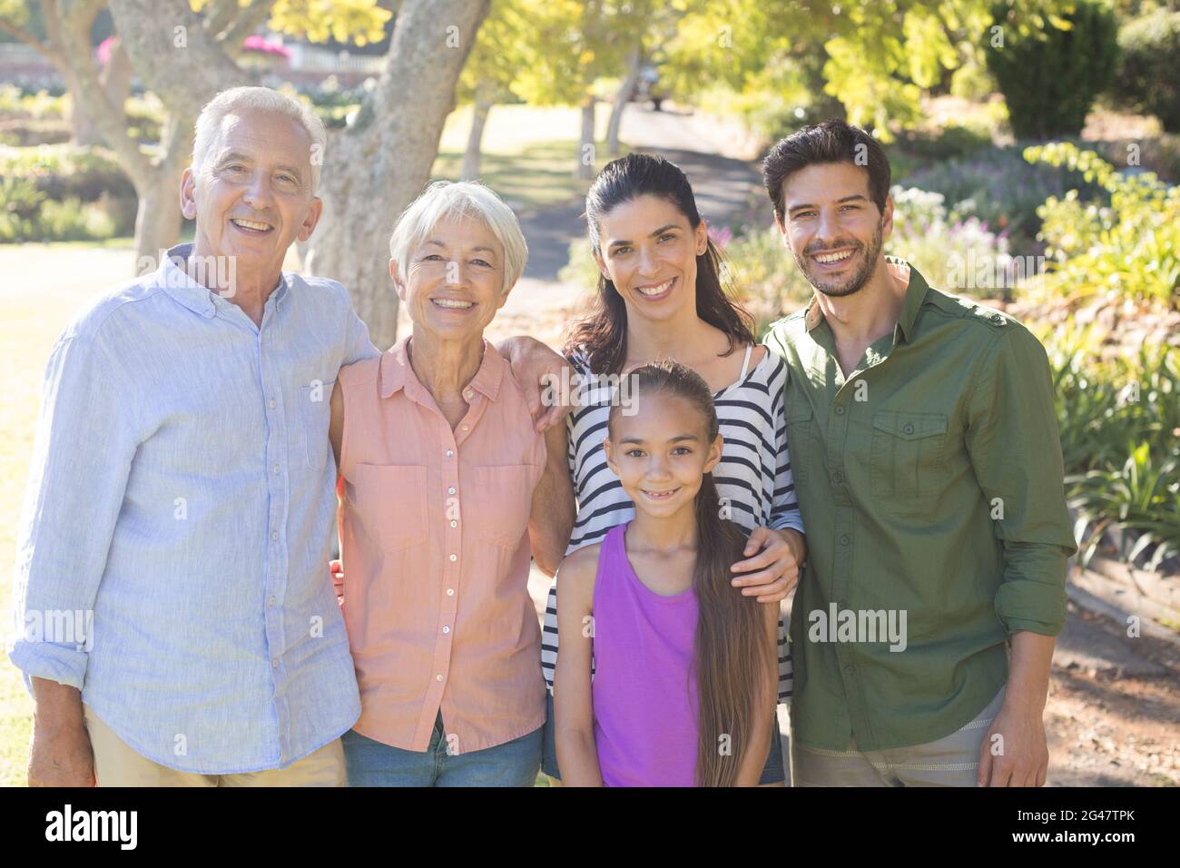 Happy family standing together in the park Stock Photo