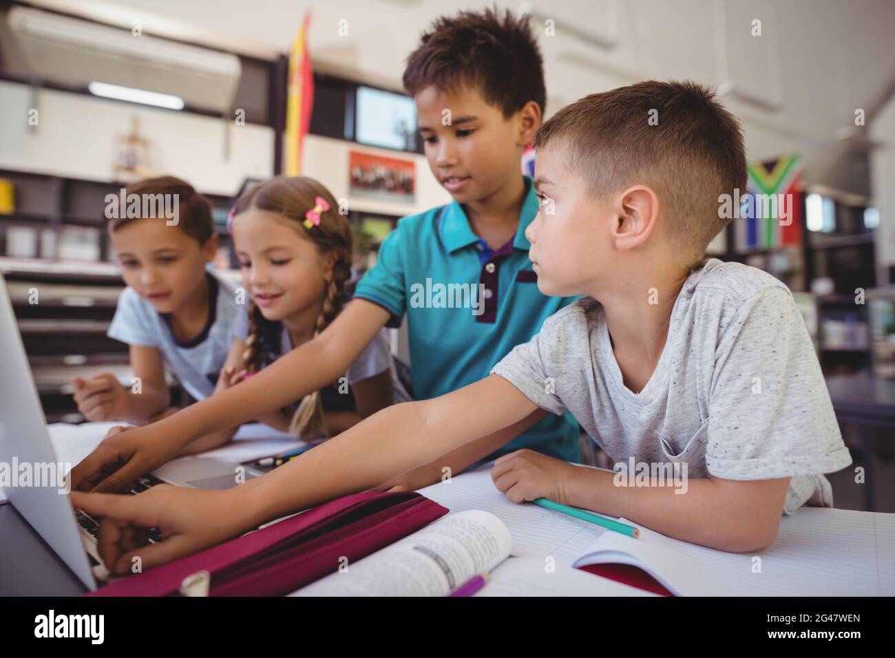Attentive schoolkid using laptop in library Stock Photo