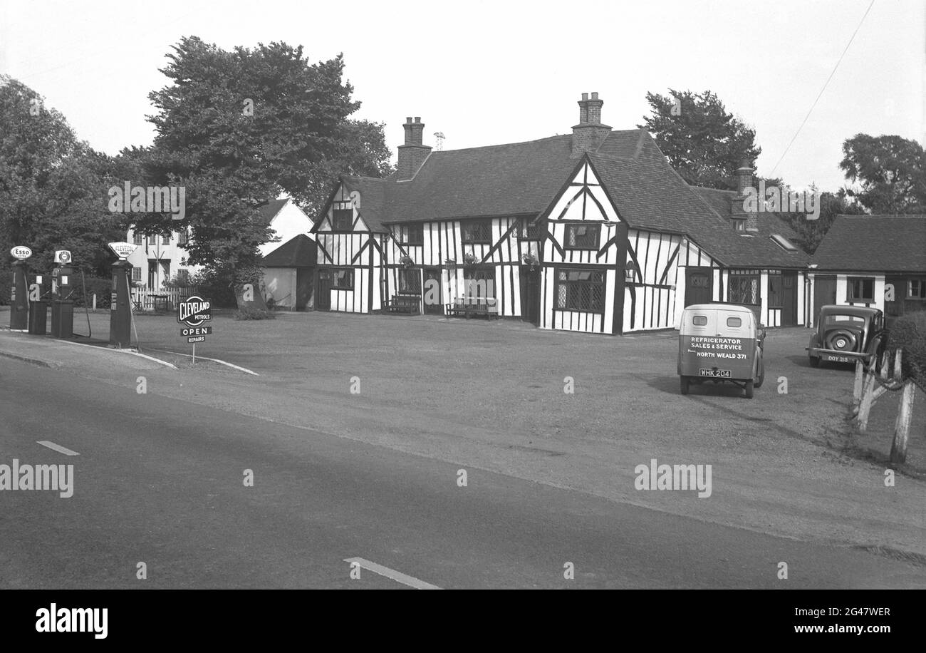 1954, historical, exterior view of an ancient Elizabethan building, Essex, England, UK, with a large forecourt and petrol pumps.  Fuels sold included Clevecol and Aero, with a sign for Cleveland Petrols. Cleveland was a British company originally established in 1920 at Trafford Park in Manchester by Norman Davis, which in 1938, was majority purchased by the US business, the Anglo-American Oil Co. In 1951 Anglo-American began calling itself Esso, after its orgins as Standard Oil (Eastern Seaboard Standard Oil). In the early 1970s all Cleveland filling stations were rebranded Esso. Stock Photo