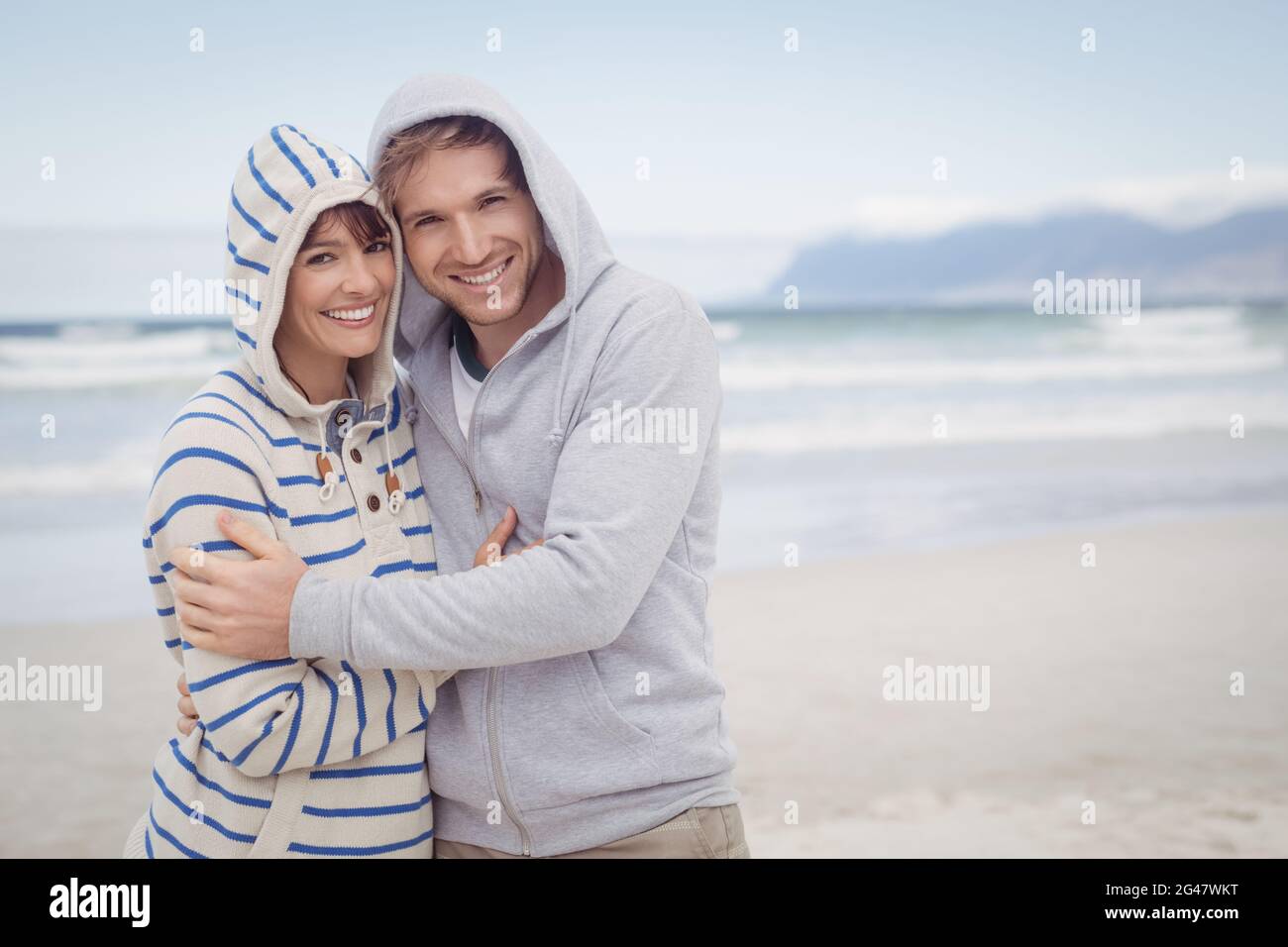 Portrait of smiling couple wearing hooded sweater during winter Stock Photo