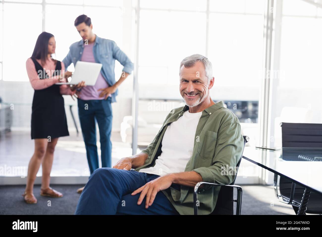 Portrait of businessman sitting on chair Stock Photo - Alamy