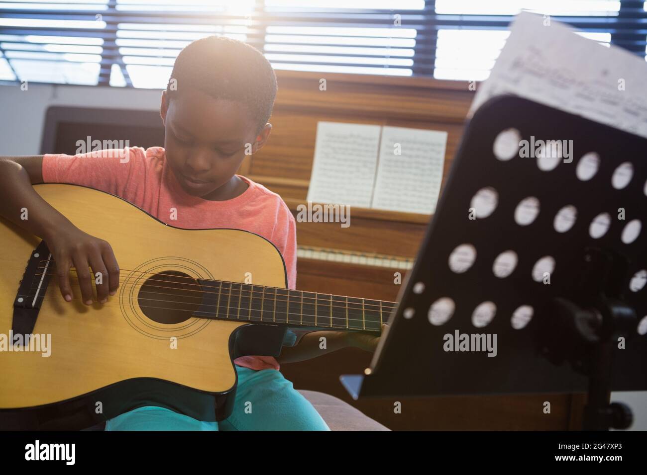 Boy playing guitar while sitting in classroom Stock Photo Alamy