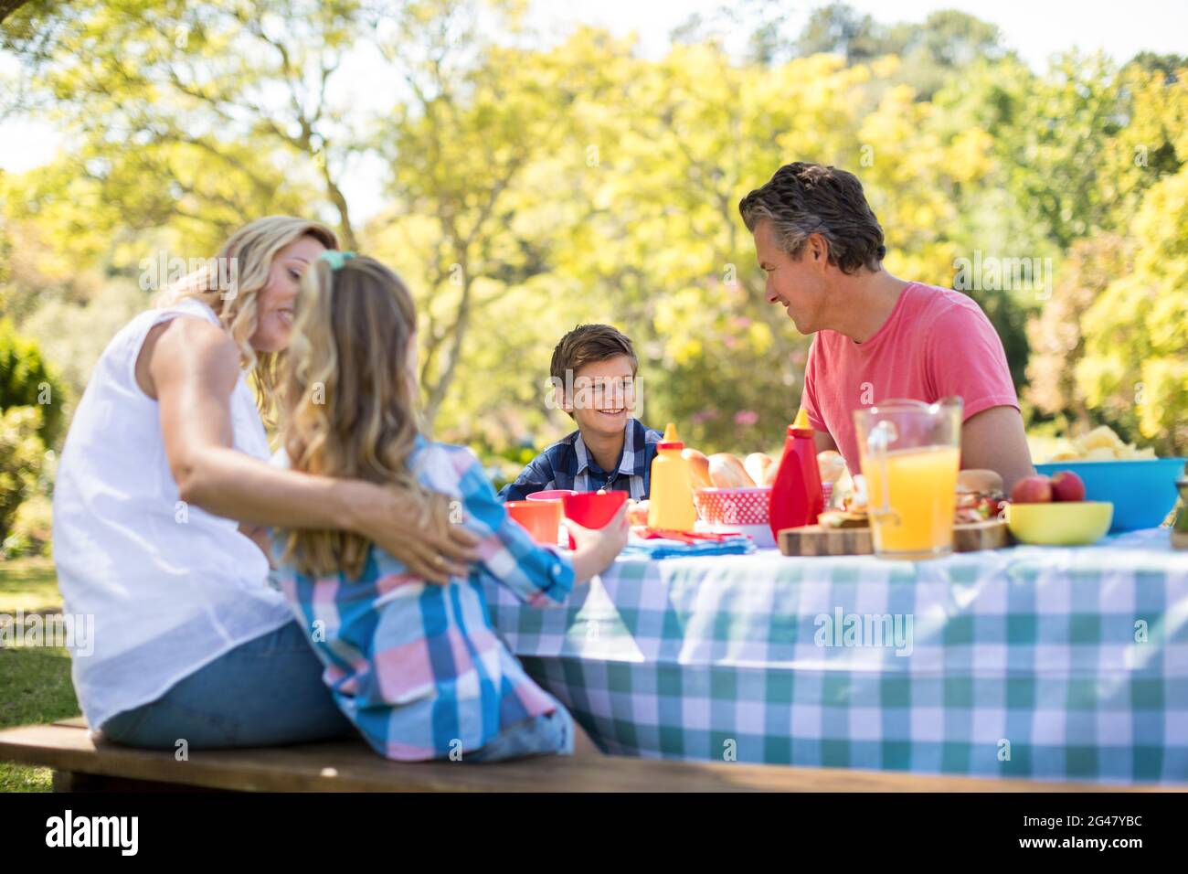 Happy family interacting with each other while having meal in park Stock Photo