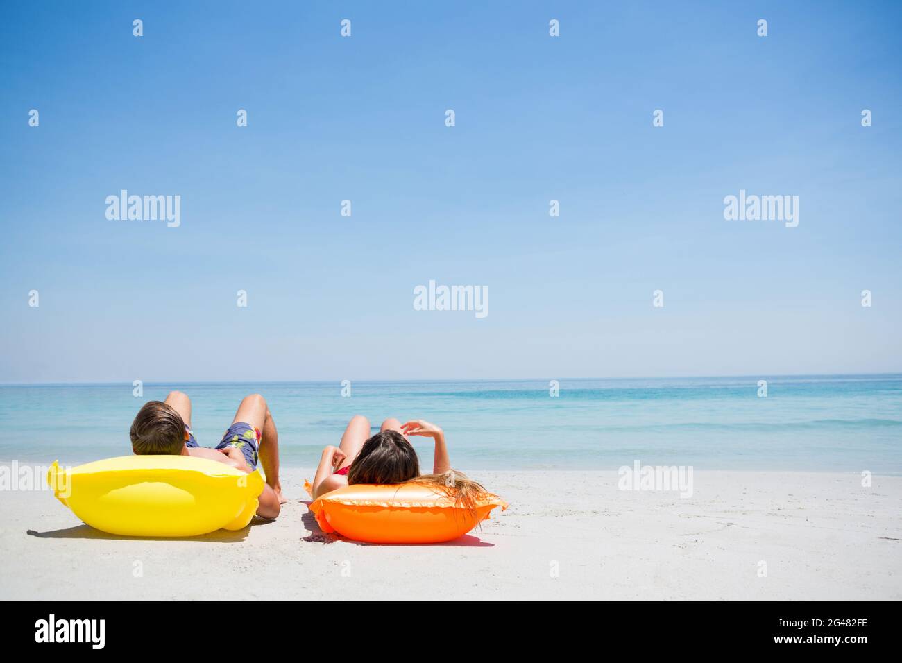 Couple relaxing at beach Stock Photo