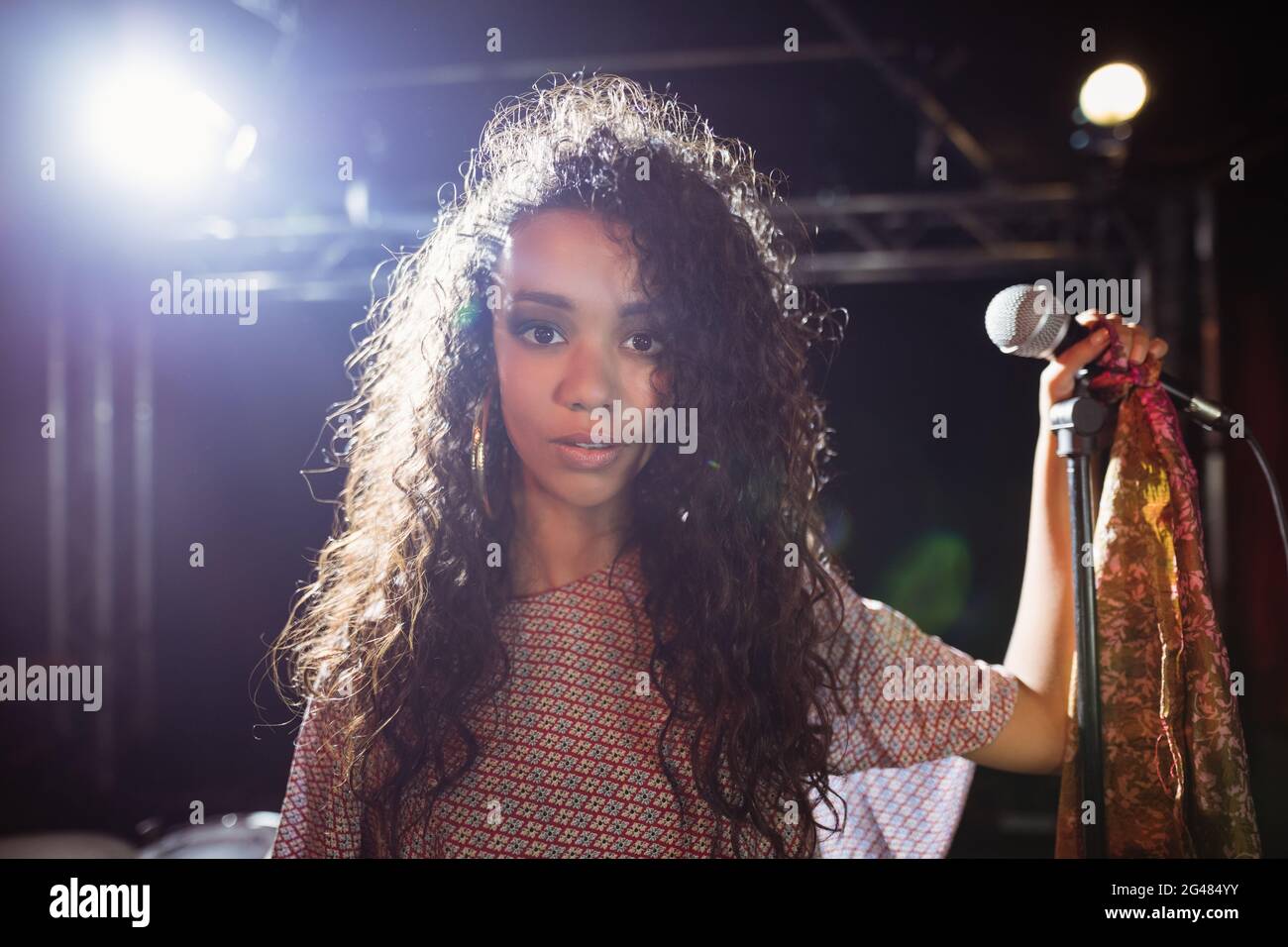 Portrait of young singer holding mic at nightclub Stock Photo - Alamy