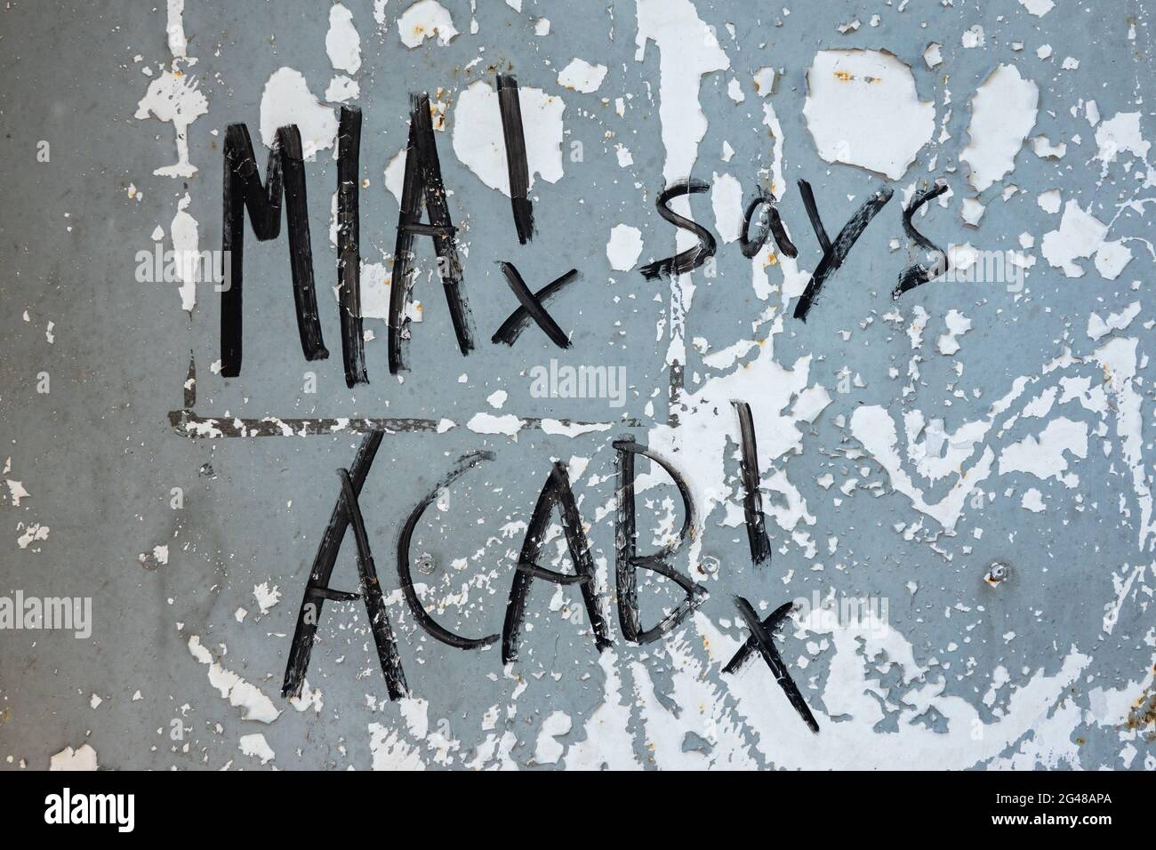MIA! says ACAB! Writing on a metal door with flaking paint in Helsinki, Finland. Stock Photo