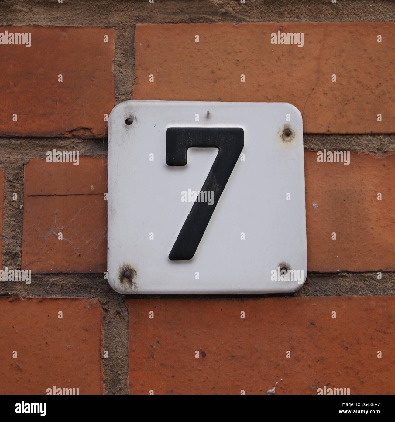 House number "7" attached to a brick wall Stock Photo Alamy