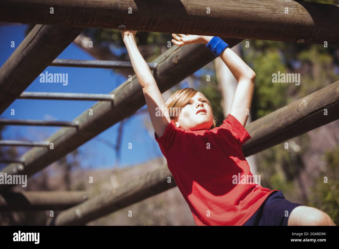 Girl climbing monkey bars during obstacle course training Stock Photo Alamy