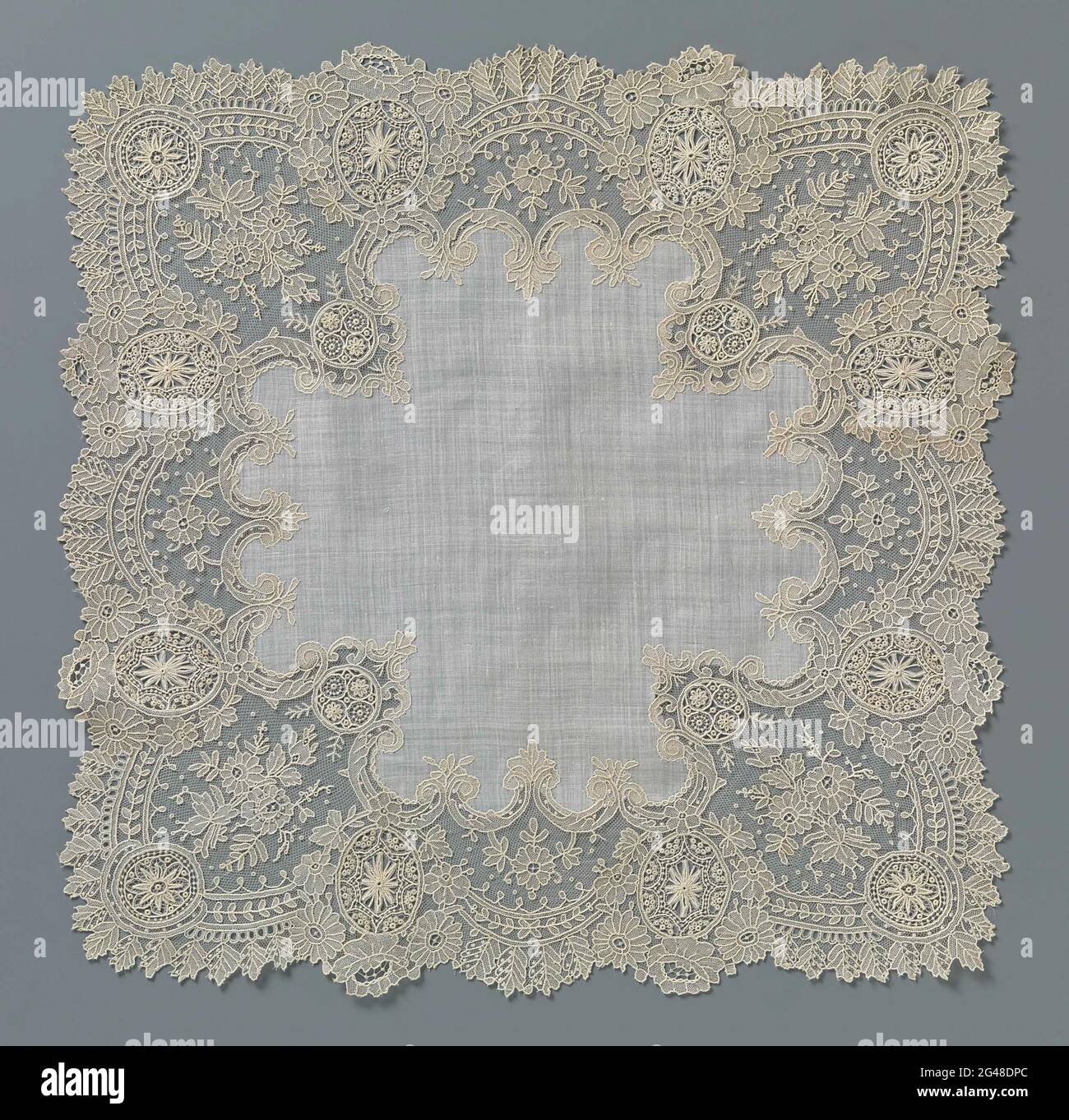 Handkerchief with a border of needle side with eight ovals and eight circles. Handkerchief with an edge of natural needle lace, Brussels mesh edge. Around a large cross-shaped batters center piece runs a narrow edge edge with eight deep shelters, the closing pieces of which are formed by eight ovals. The angular shells each exhibit two above-standing circles. The sculpture consists of a leaf branch and a edge of leaves, which form the scallops. Small, hollow C-Volutes form the inner edge. Stock Photo