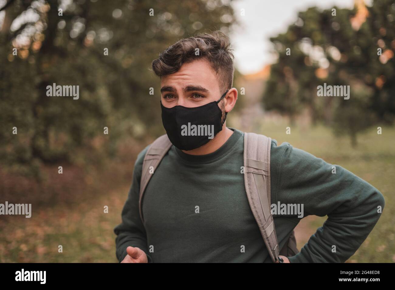 Young man wearing a face mask in a park Stock Photo - Alamy
