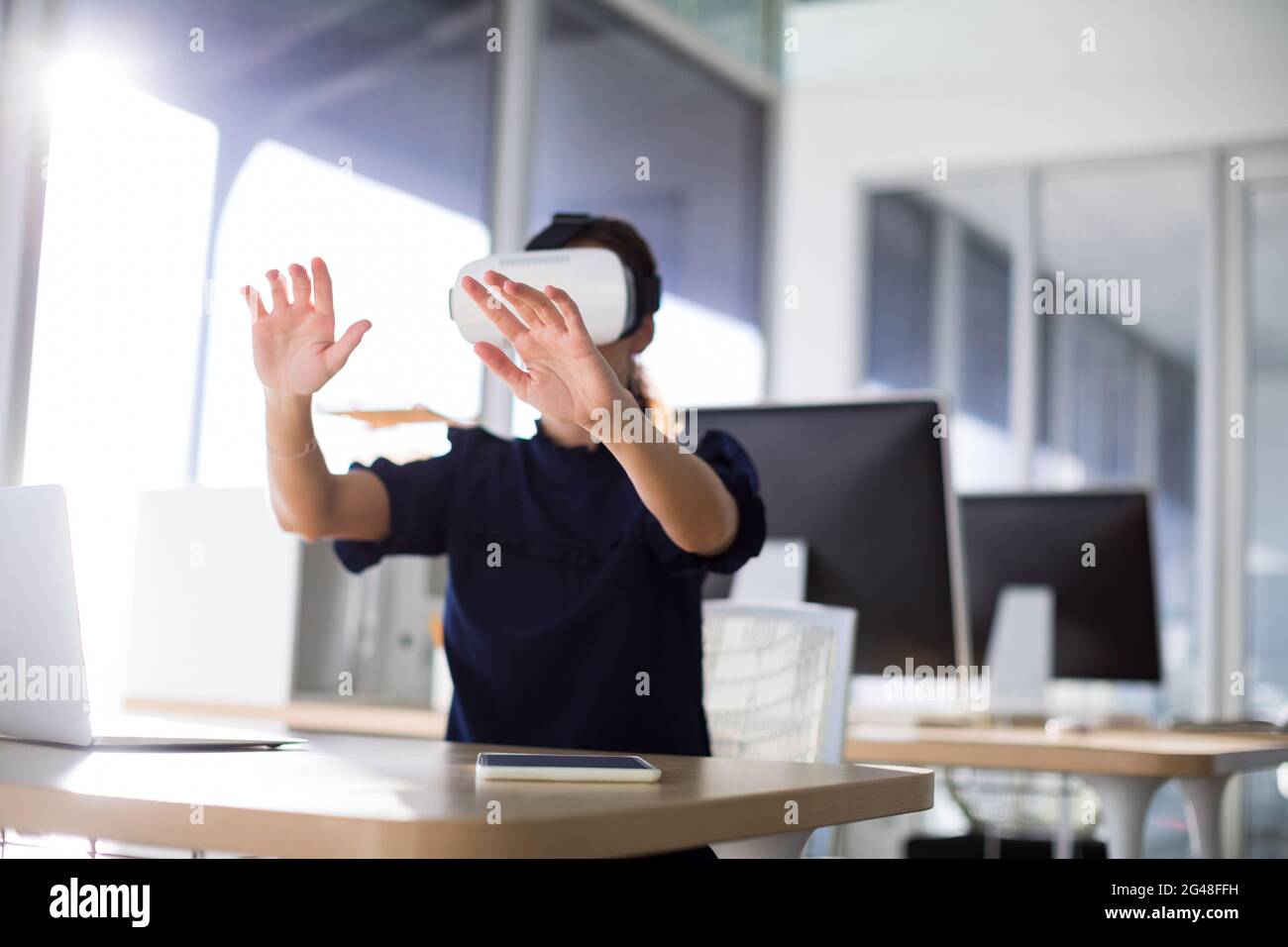 Female executive using virtual reality headset Stock Photo - Alamy