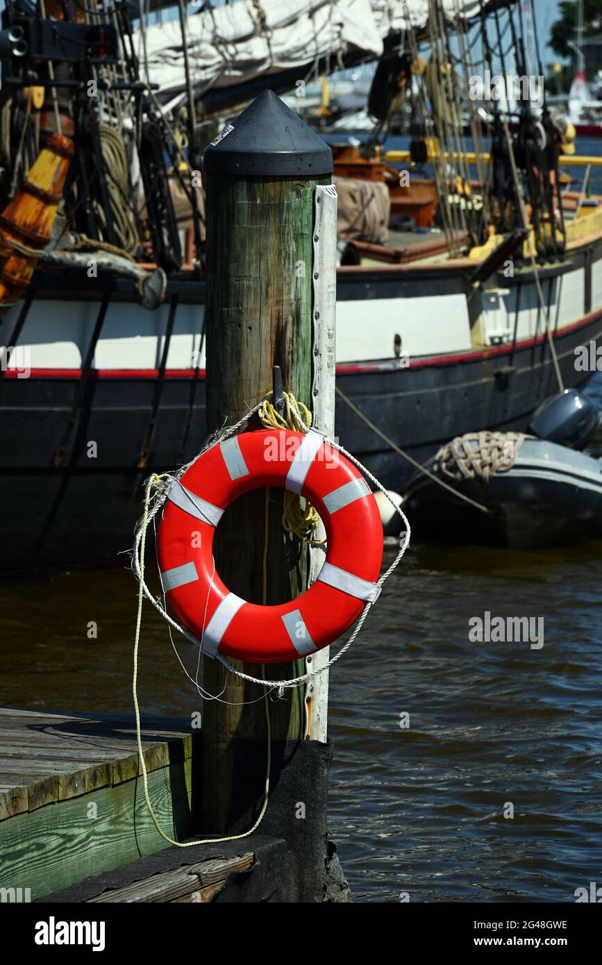 A life preserver ring on a post at the end of a pier. Stock Photo