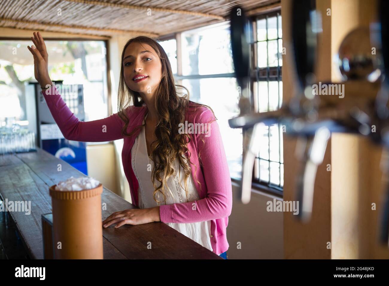 Young woman gesturing at bar Stock Photo