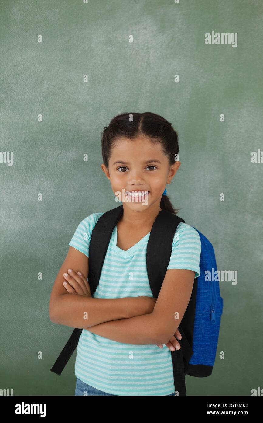 Portrait of cute school girl standing with arms crossed Stock Photo - Alamy