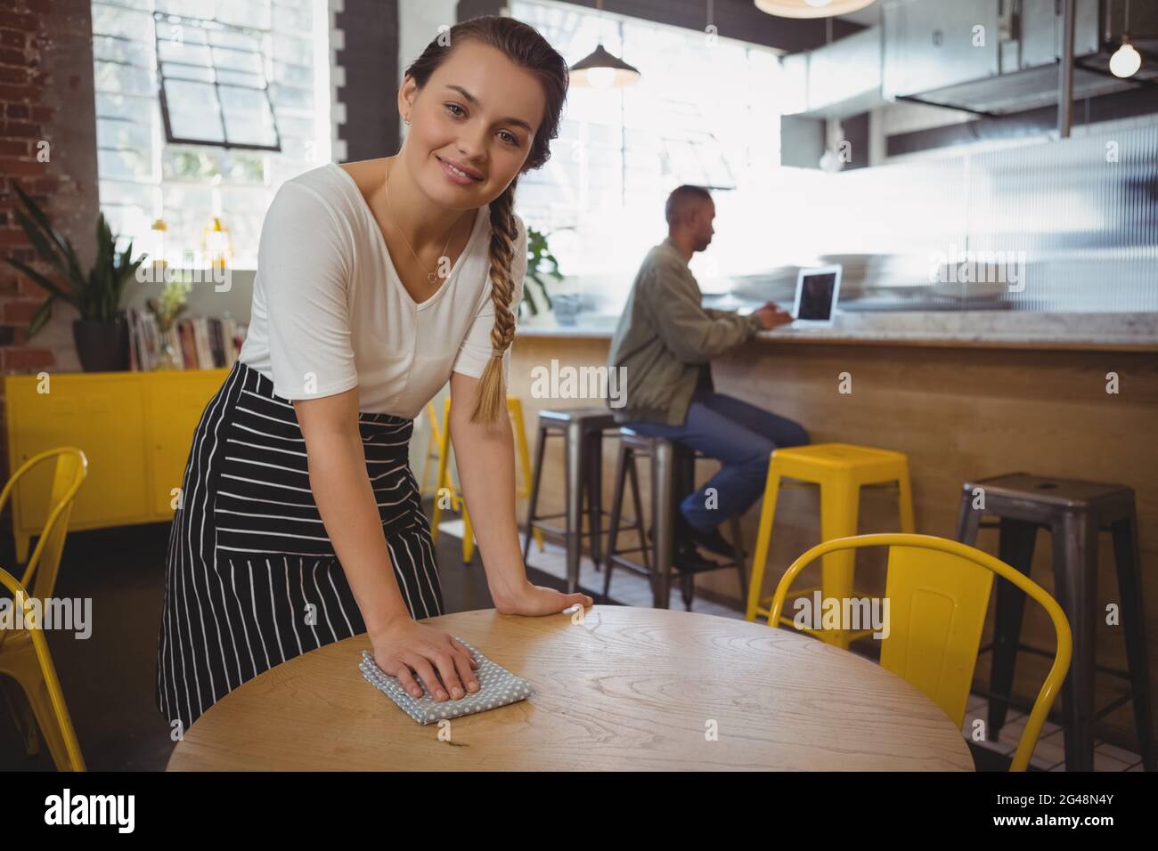 Portrait of waitress cleaning table Stock Photo