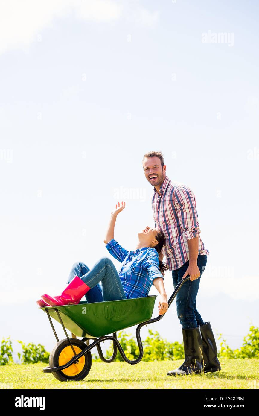 Man pushing woman sitting in wheelbarrow Stock Photo - Alamy