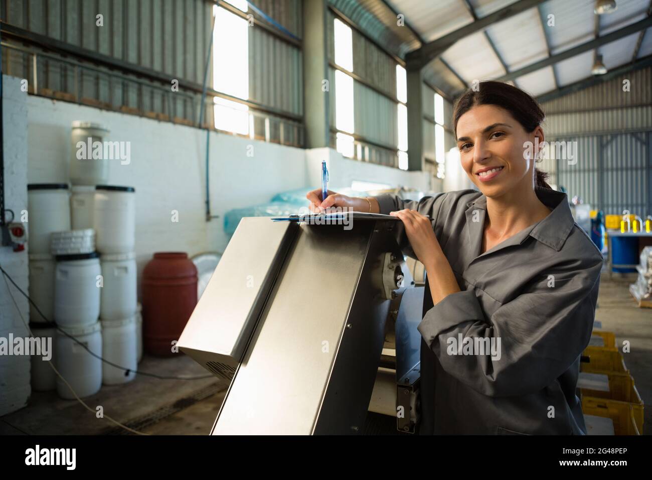 Female worker writing on clipboard in olive factory Stock Photo - Alamy