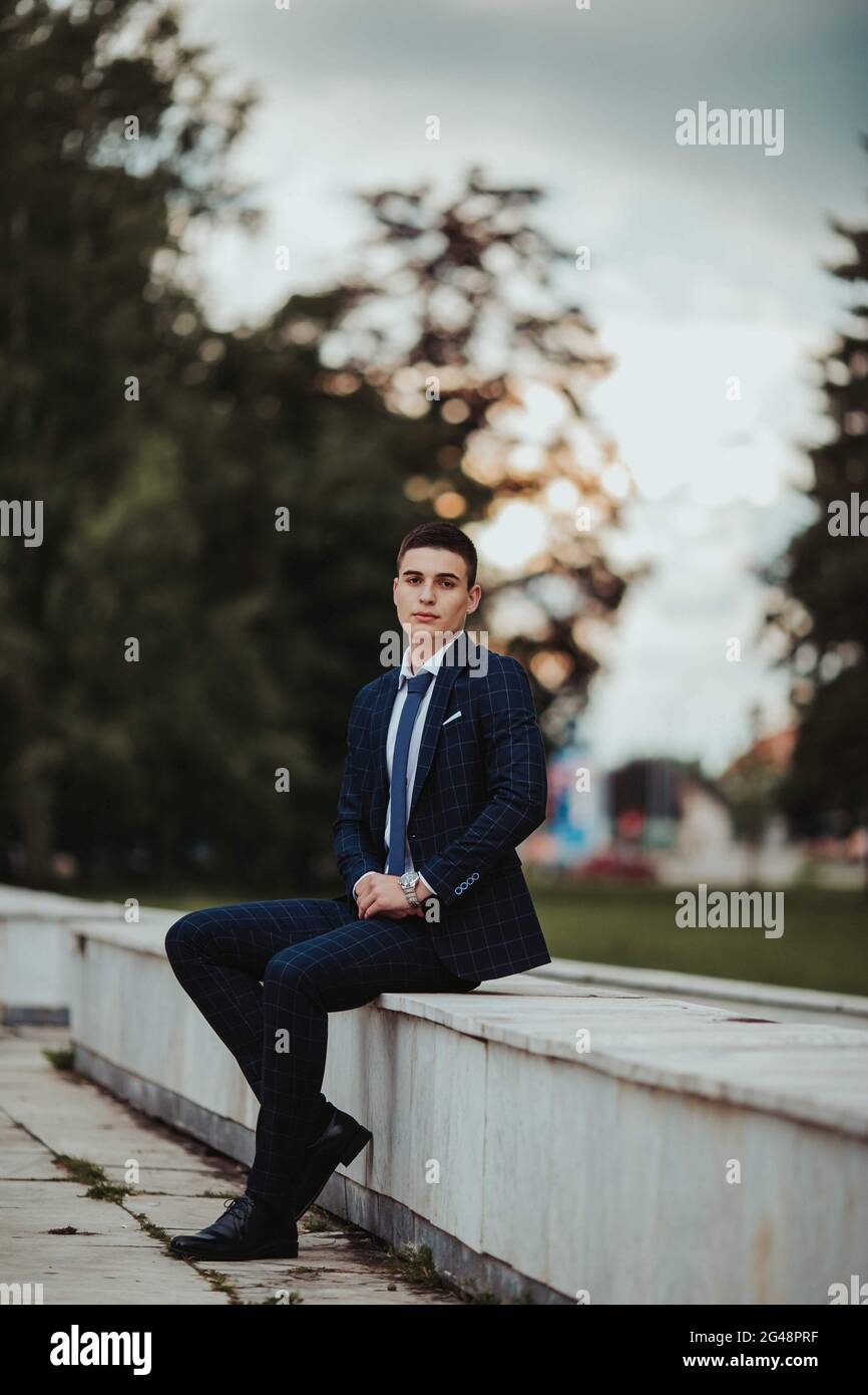 Caucasian young businessman in a suit and tie sitting in the park Stock ...