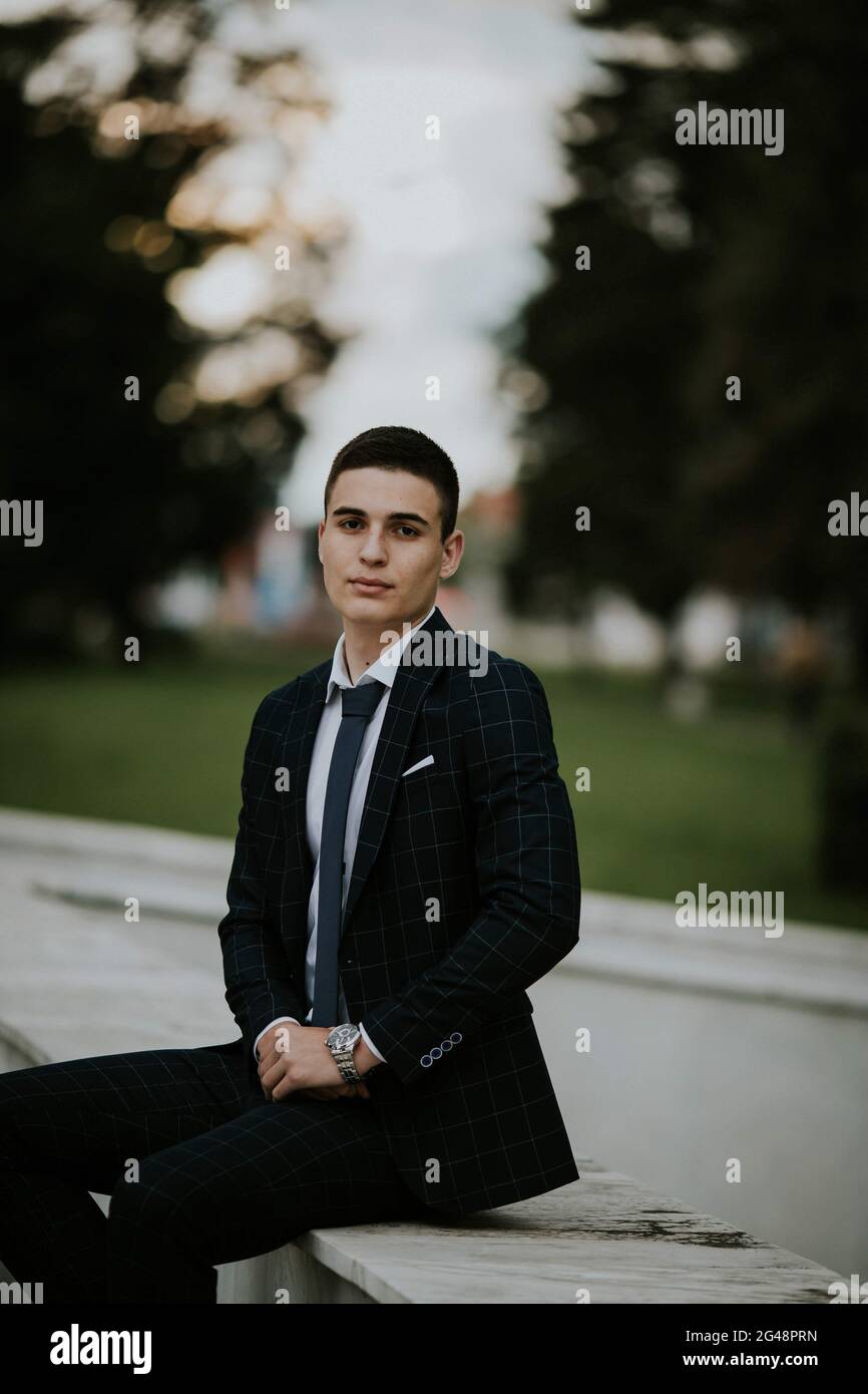 Caucasian young businessman in a suit and tie sitting in the park Stock ...