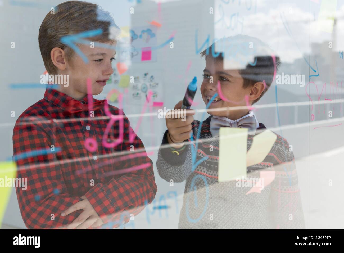 Kids as business executives discussing over whiteboard Stock Photo