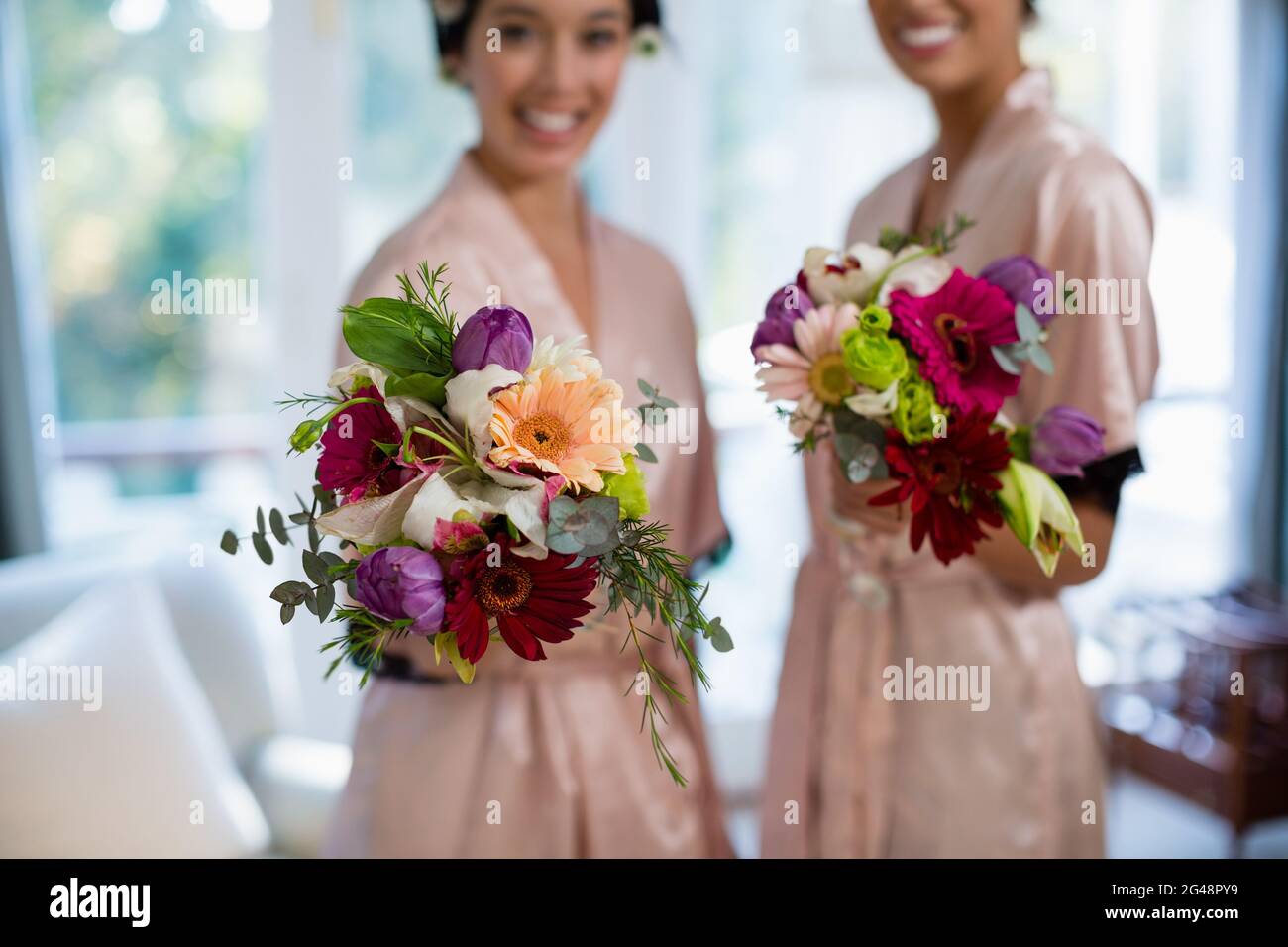 Two bridesmaids holding bouquet hi-res stock photography and images - Alamy