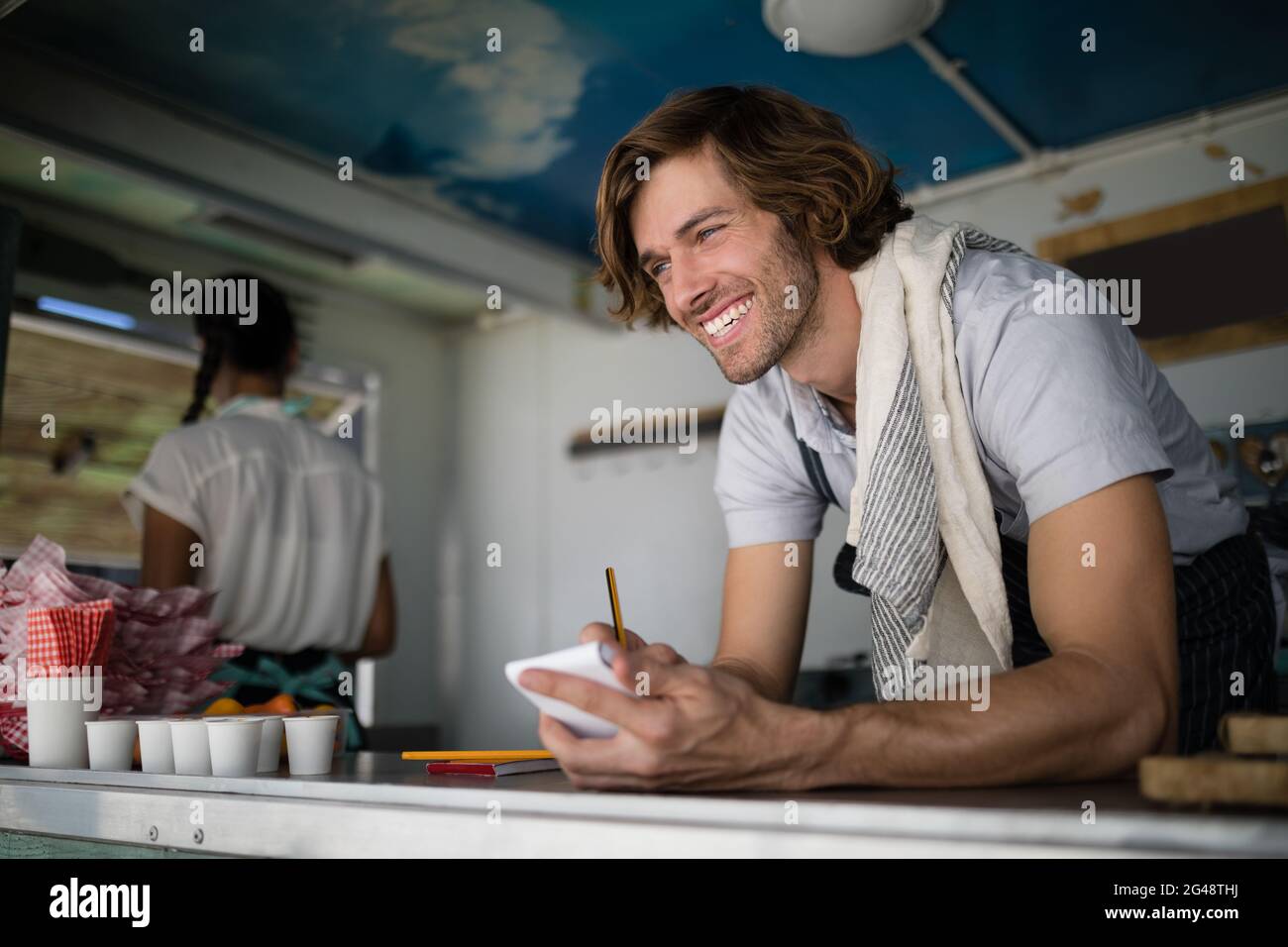 Waiter writing in notepad Stock Photo - Alamy